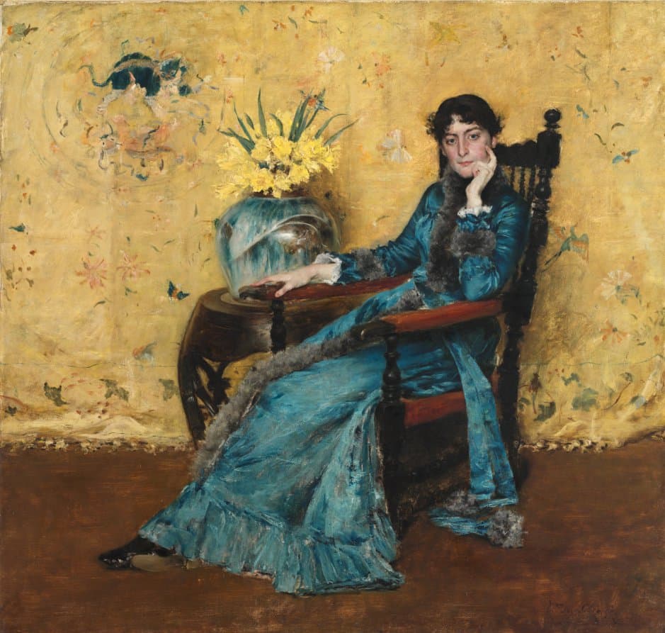 woman in a blue dress sitting in a yellow room