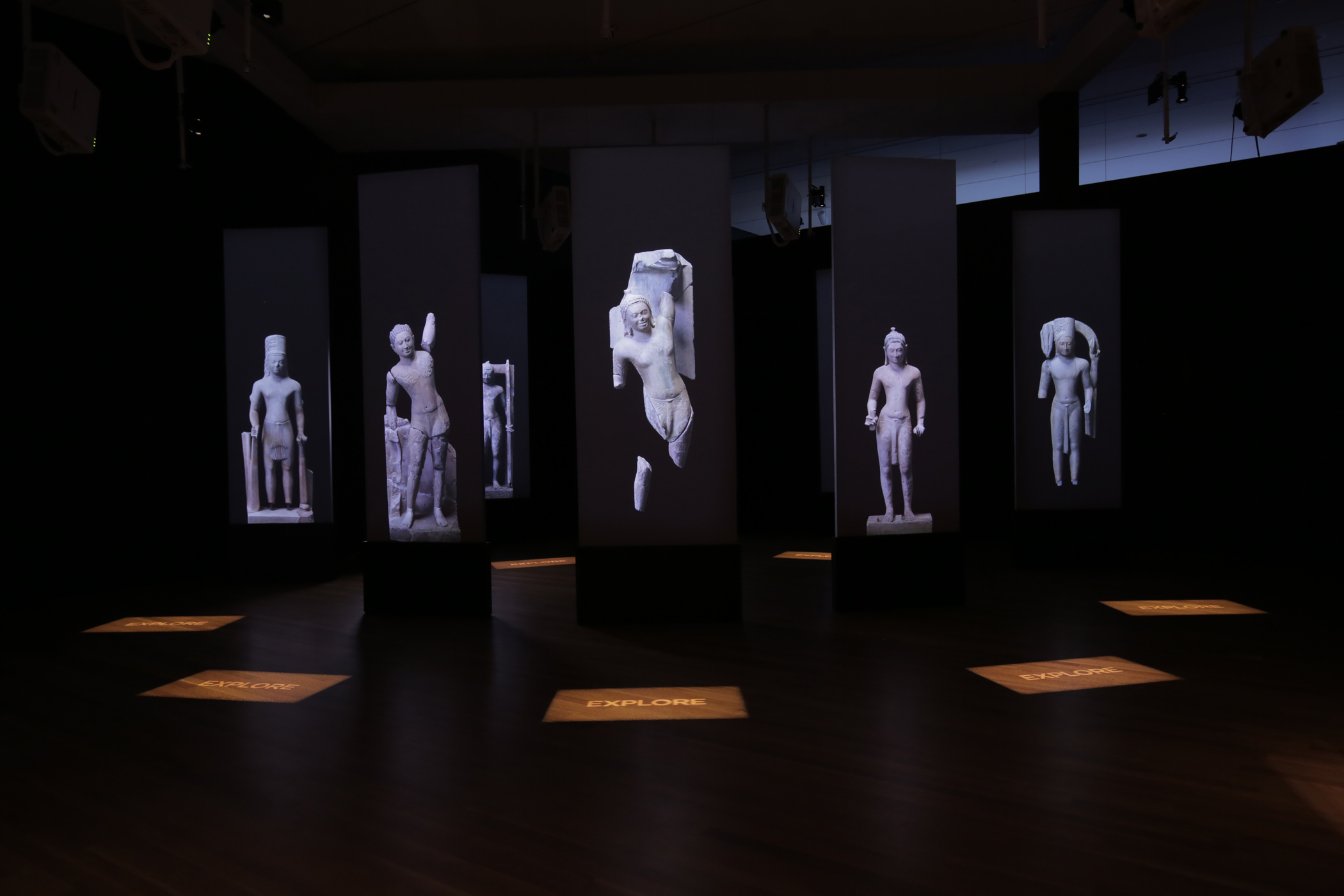 Dark room with 8 projection screens with life-size sculpture