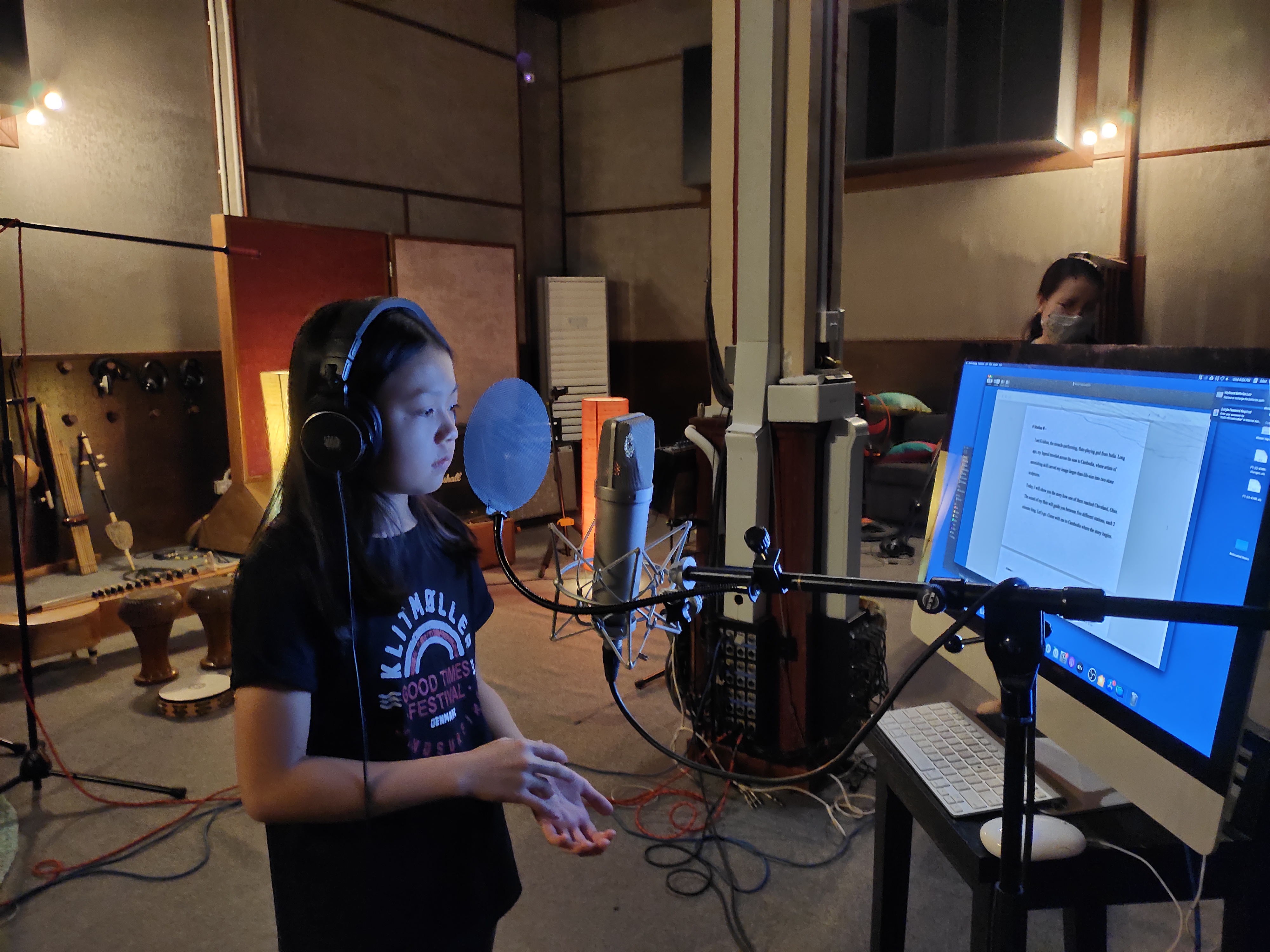 a child in front of a microphone reading text