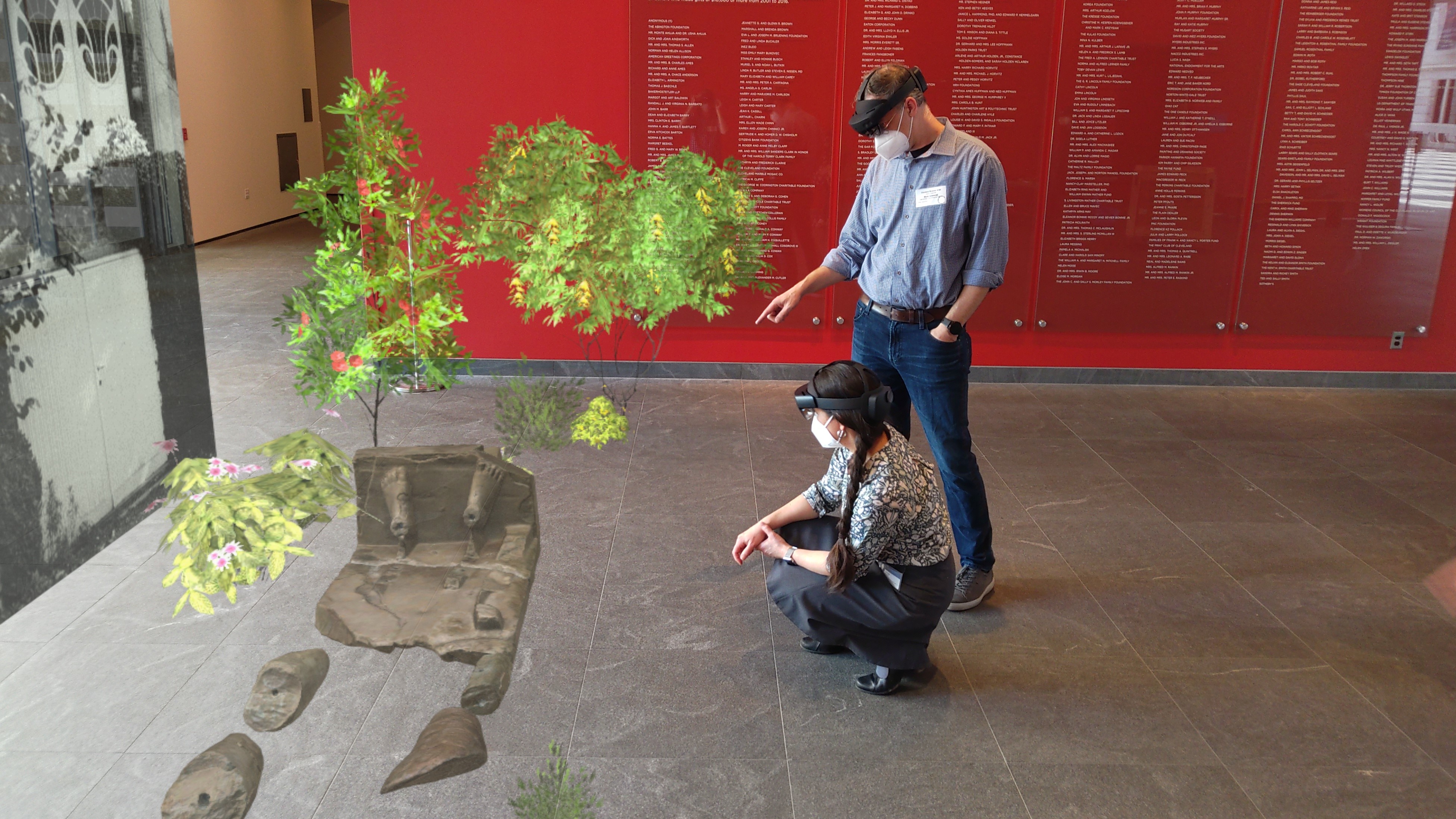 two people wearing AR headsets crouching down to investigate augmented images 