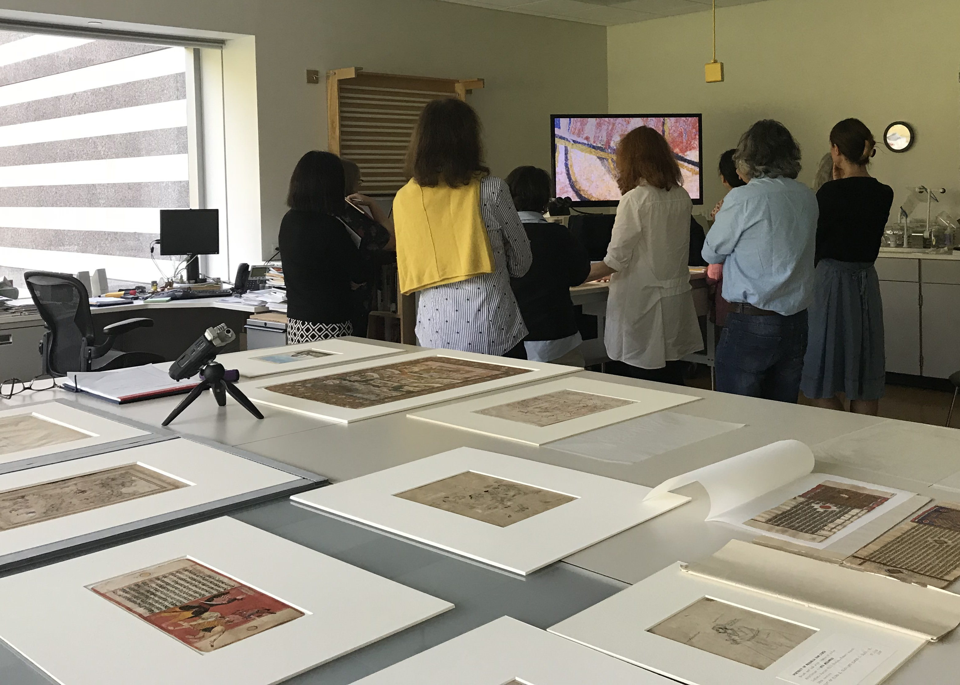 Using a stereomicroscope equipped with a video camera, colloquy participants simultaneously view a magnified image of a painting on a large screen monitor.