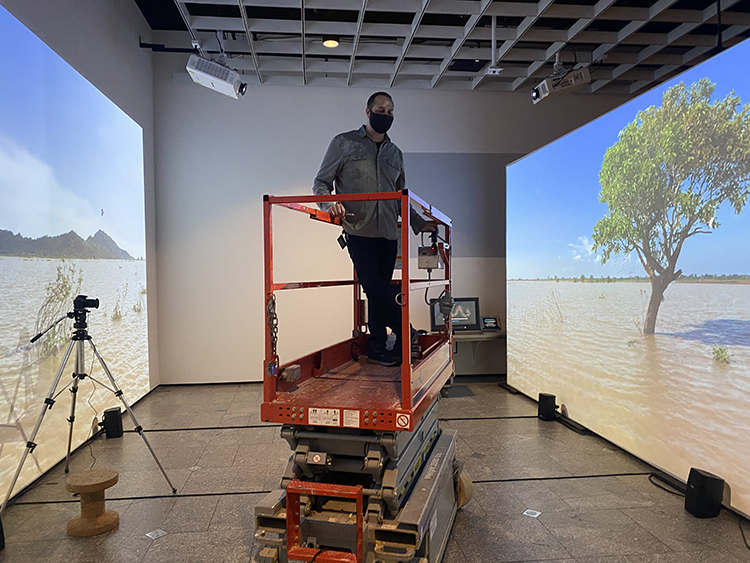 a man on a lift surrounded by screens